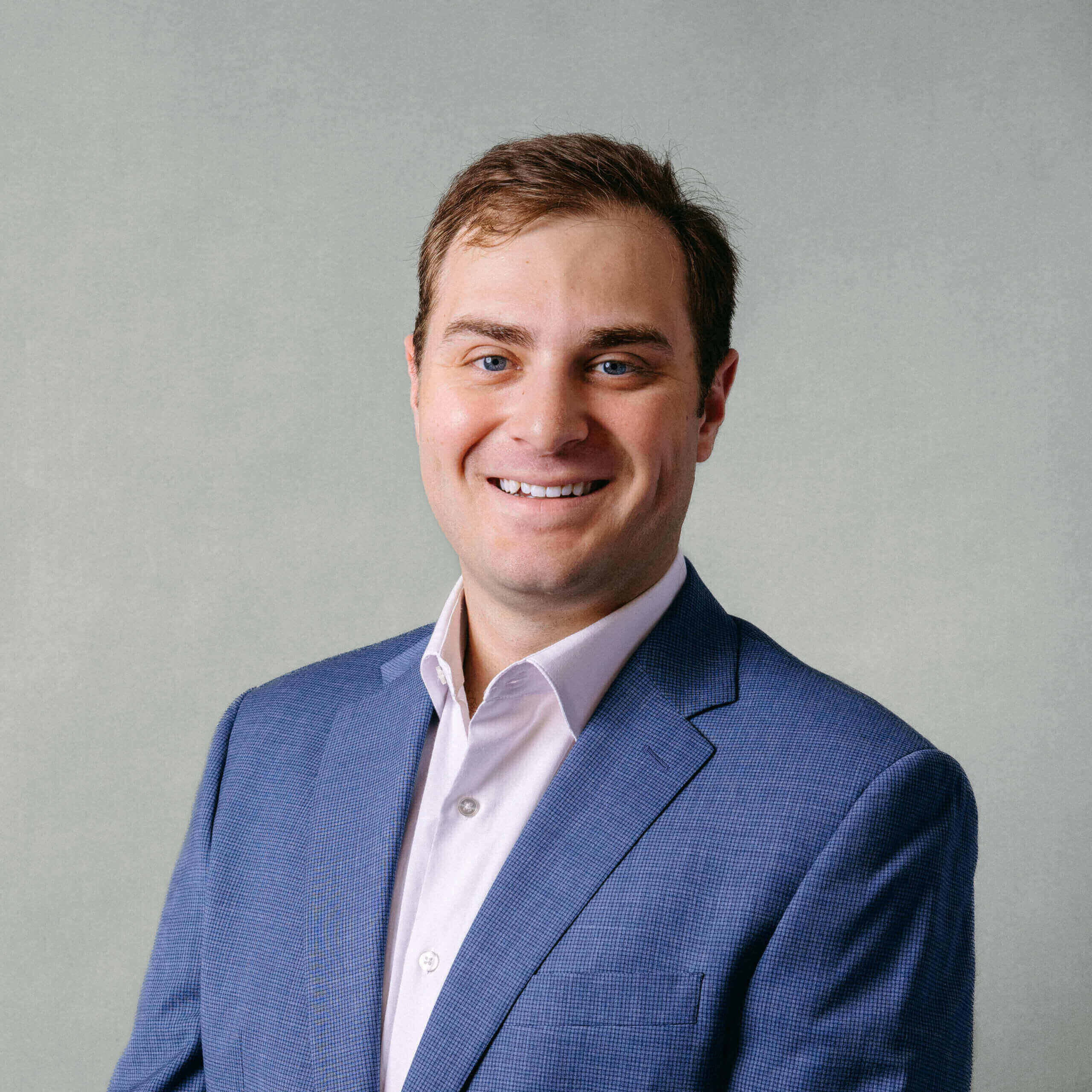 Smiling man in a blue suit jacket.